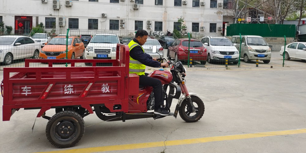 教练骑着三轮摩托车